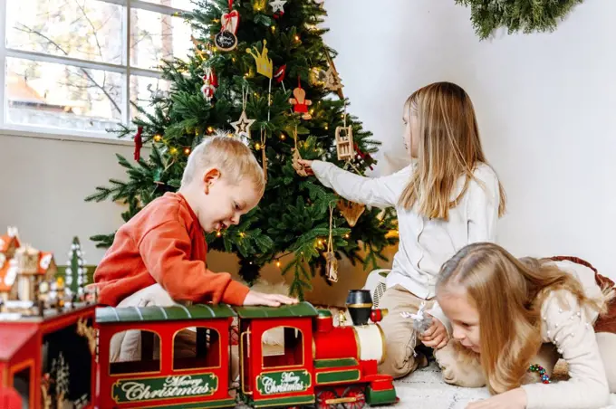 Siblings playing with toys at home during Christmas