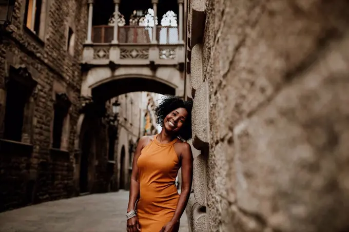 Smiling woman leaning on wall, Barcelona, Spain