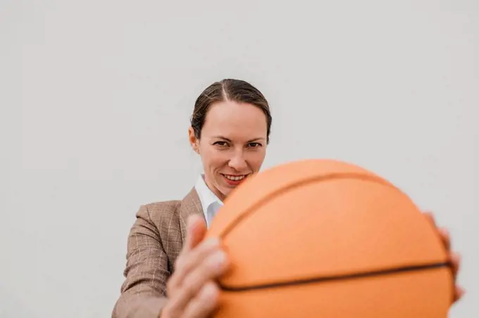 Smiling female professional with basketball during break