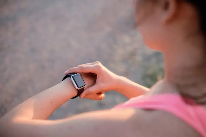 Fit young athlete checking tome on smart watch