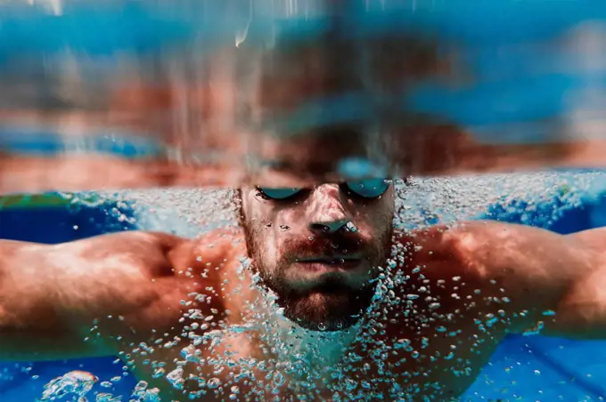 Close-up of swimmer diving underwater in swimming pool