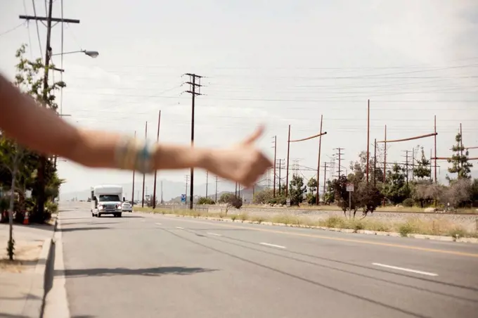 Hand of female hailing a ride during sunny day