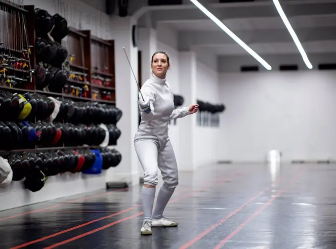 Woman¶ÿin fencing outfit practicing at gym