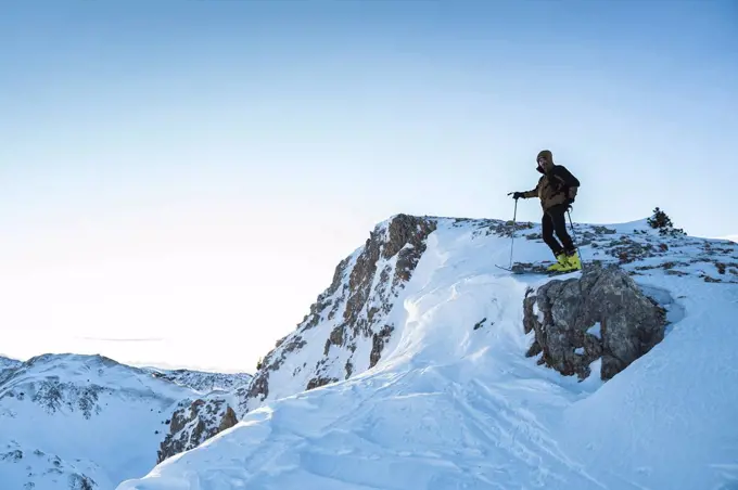 Male mountain climber on mountain summit against sky