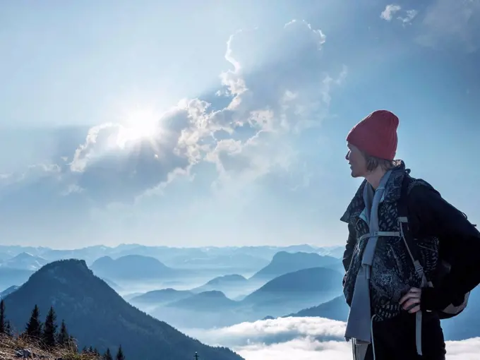 Female tourist standing on Heuberg mountain against cloudy sky during sunny day