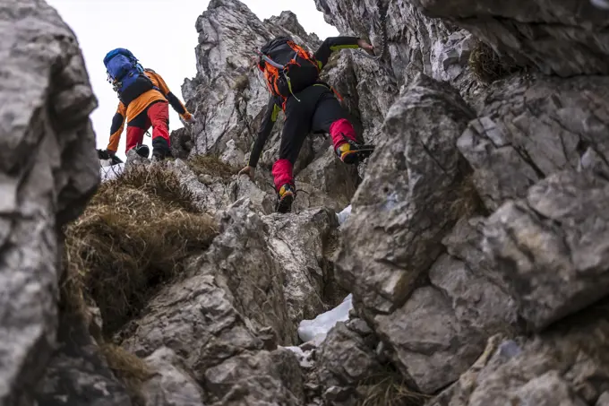 Men with backpack climbing on rocks