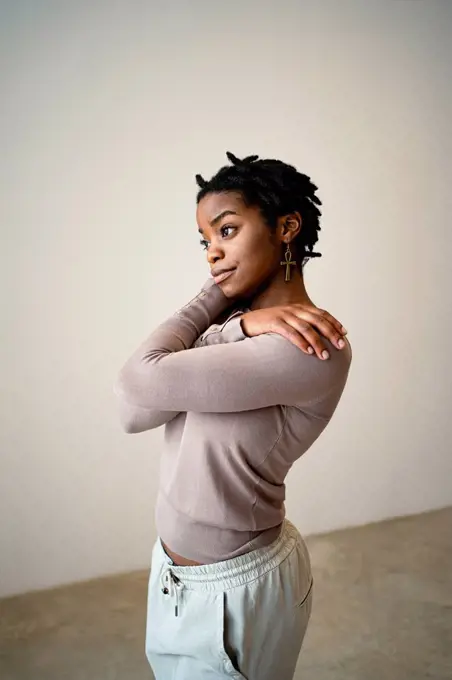 Young woman self hugging at home