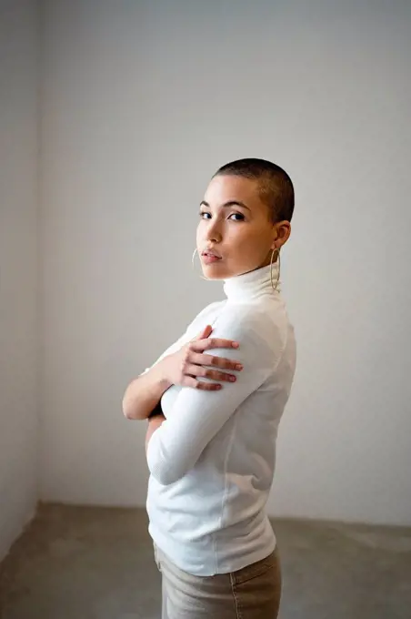 Confident woman with arms crossed at home