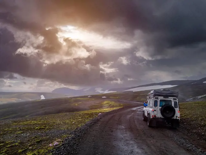 Dramatic sky over off-road car driving along remote dirt road at¶ÿFjallabak Nature Reserve