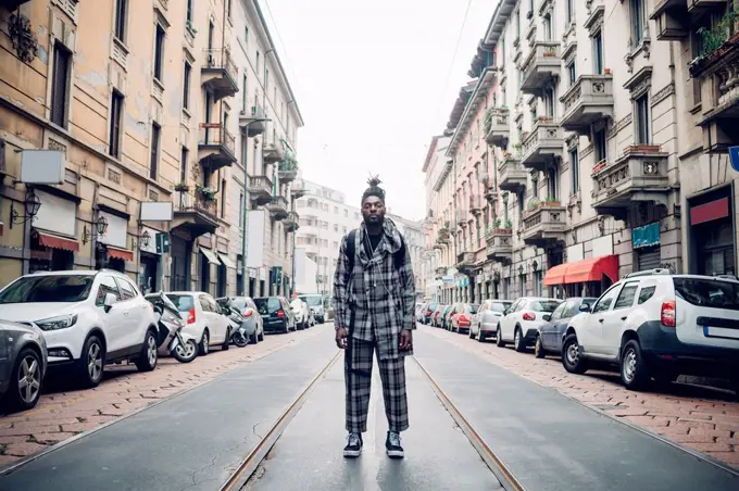 Young fashionable man standing on tramway in city