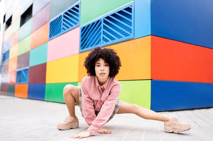 Female dancer dancing while crouching on footpath