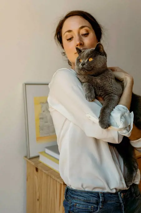 Woman holding Chartreux cat at home