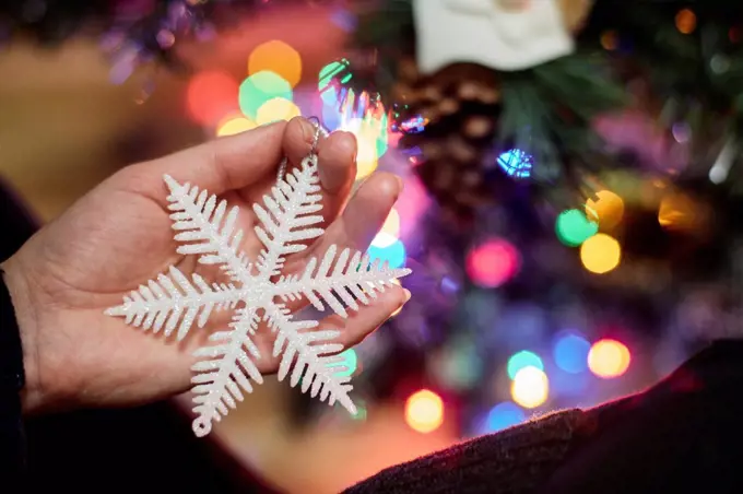 Woman's hand holding Christmas ornament, close-up