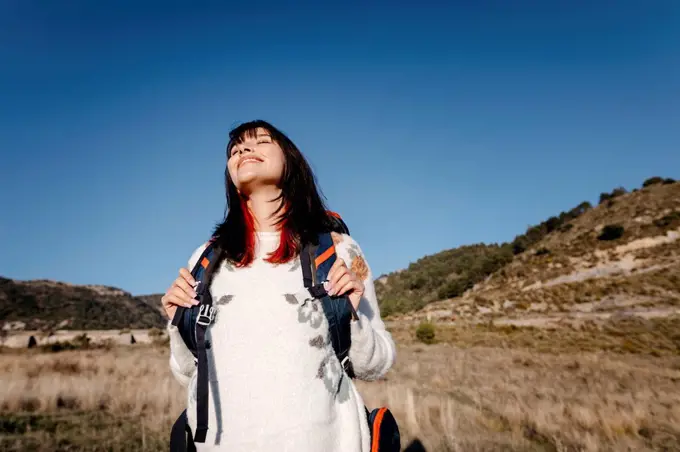 Serene woman standing below sky