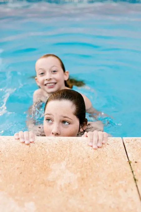 Siblings playing in swimming pool together