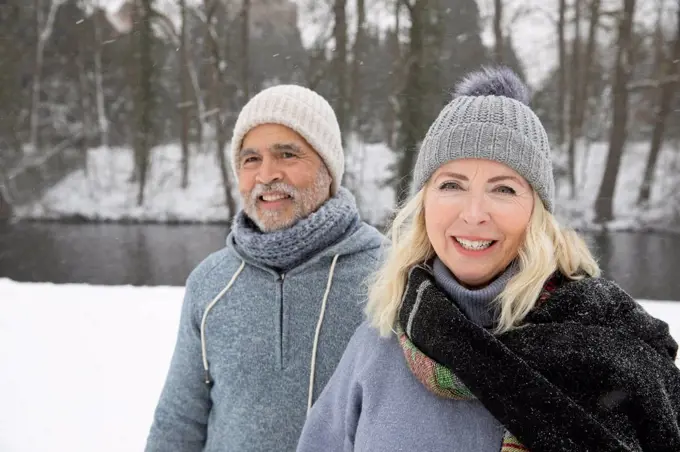 Smiling senior woman with man at park during winter