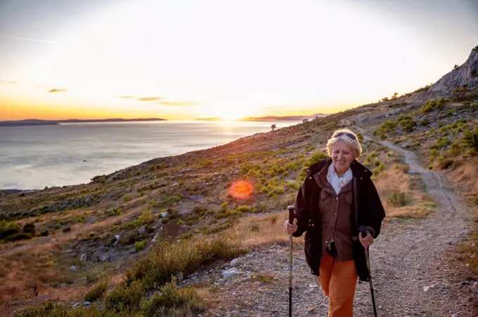 Smiling senior woman hiking near Adriatic sea in Omis, Dalmatia, Croatia