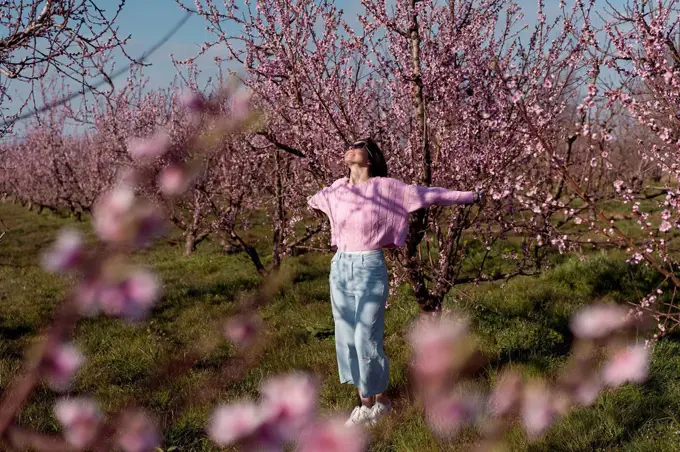 Woman with arms outstretched standing in field