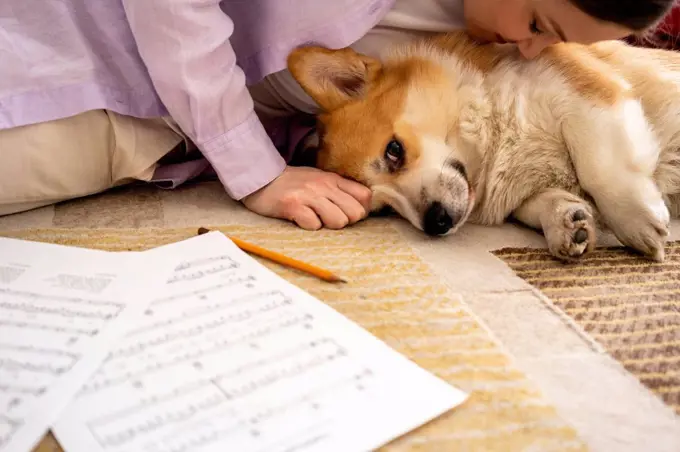 Mid adult woman kissing relaxed dog at home