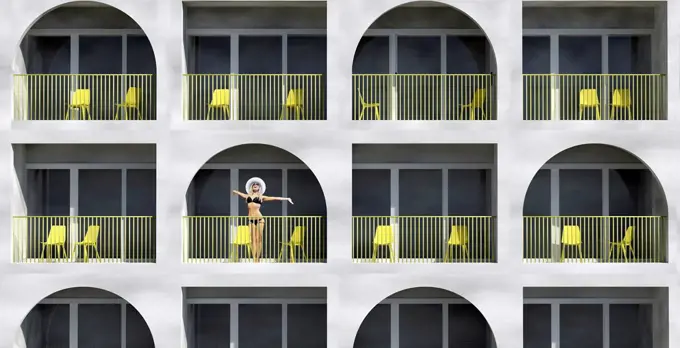 Woman wearing bikini standing in balcony of hotel during vacation