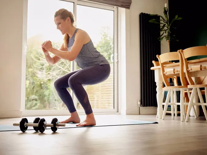 Active woman practicing squats at home