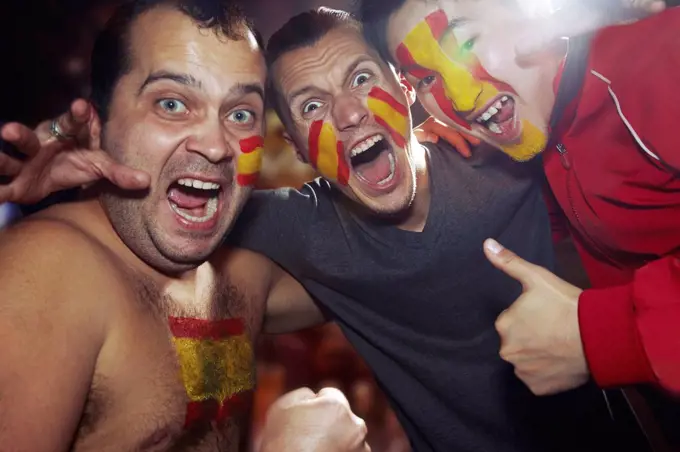 Male sports fan with Spanish flag paint on face