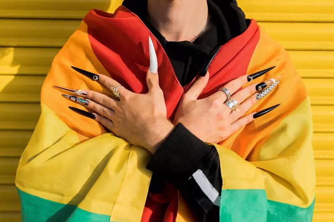 Gay man wrapped in rainbow flag