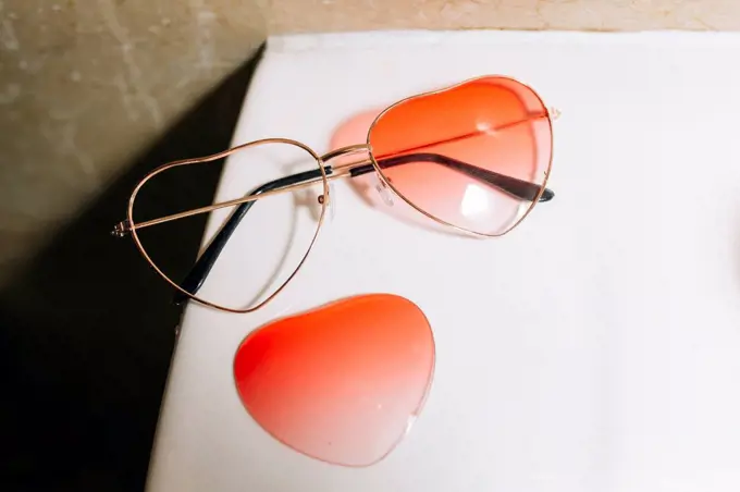 Broken orange heart shape sunglasses on table