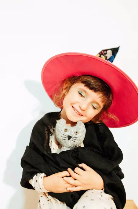 Girl with Halloween costume holding stuffed toy