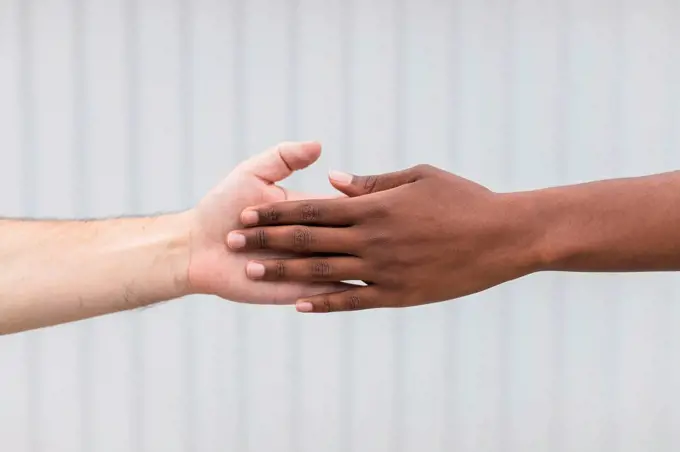 Woman and man touching hands by white wall