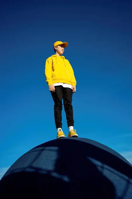 Boy looking away while standing at skateboard park