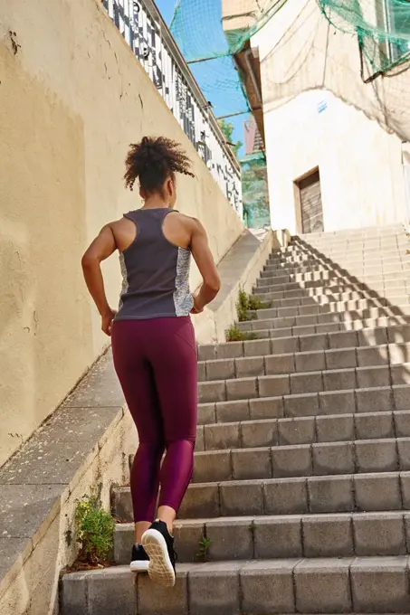 Sportswoman jogging on steps