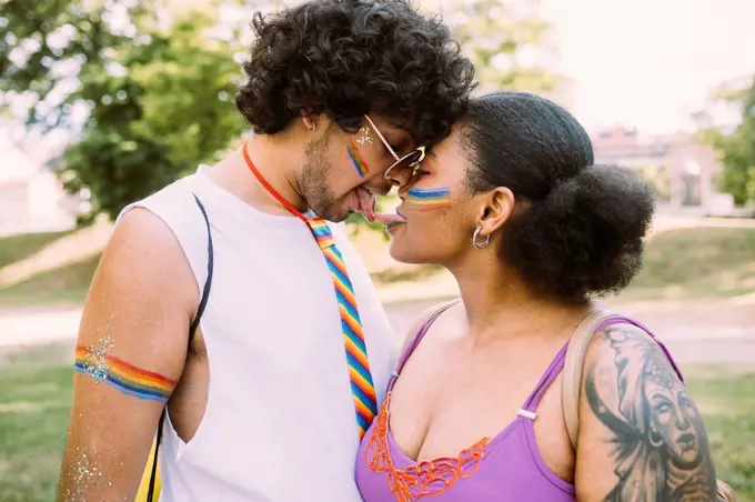 Young couple touching tongues in park