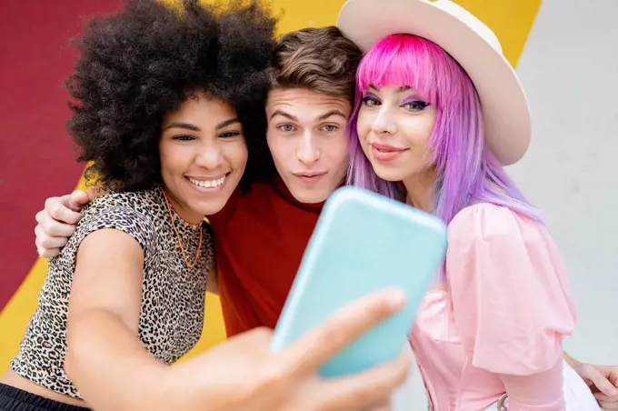 Smiling Afro woman taking selfie with friends
