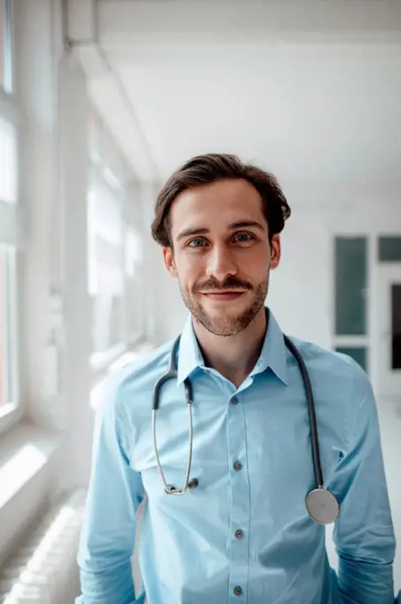 Smiling male doctor with stethoscope in office