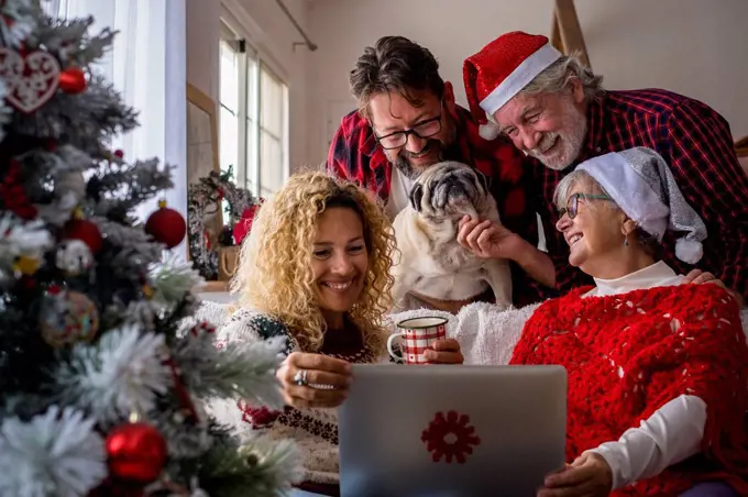 Family with dog attending video call through laptop at home