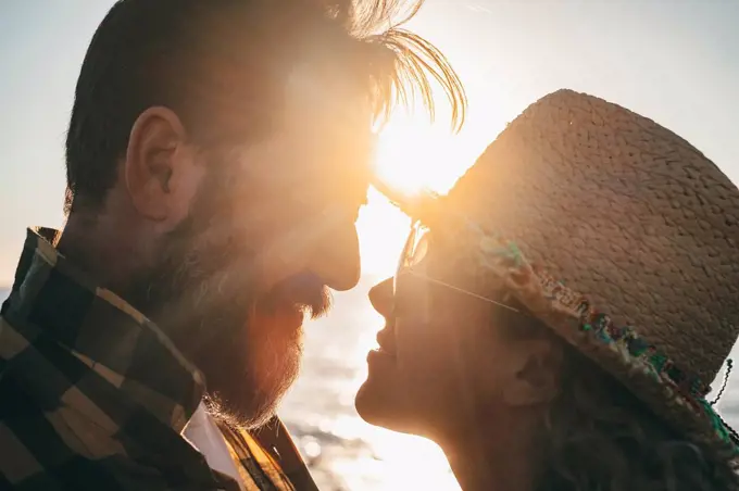 Bearded man romancing with girlfriend during sunset