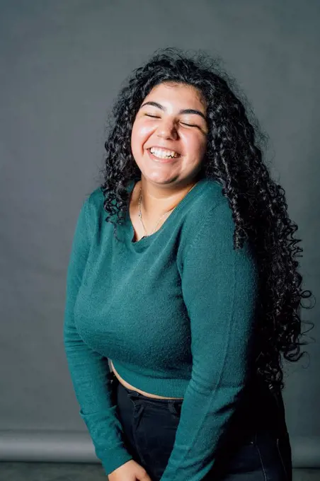 Happy young oversized woman laughing in studio