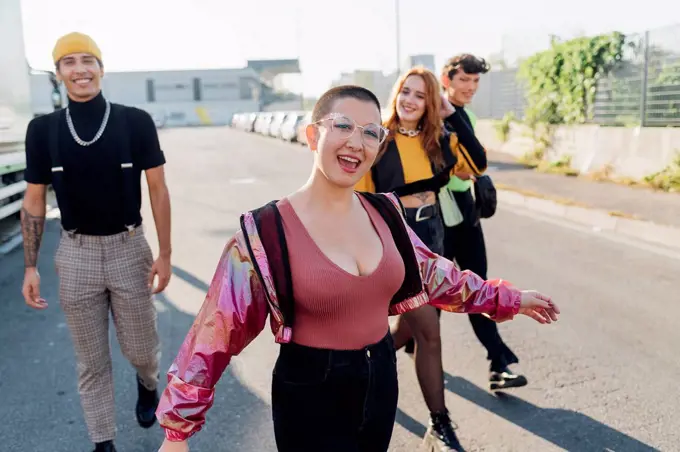 Happy woman walking with friends in background on road