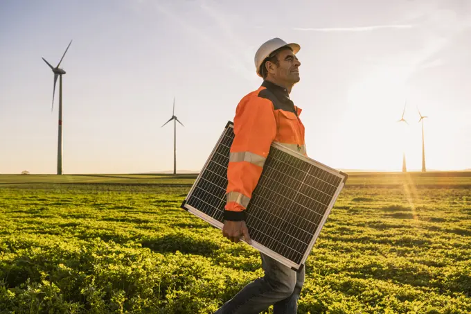 Engineer with solar panel looking away