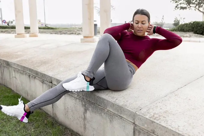 Woman doing exercising on concrete at park