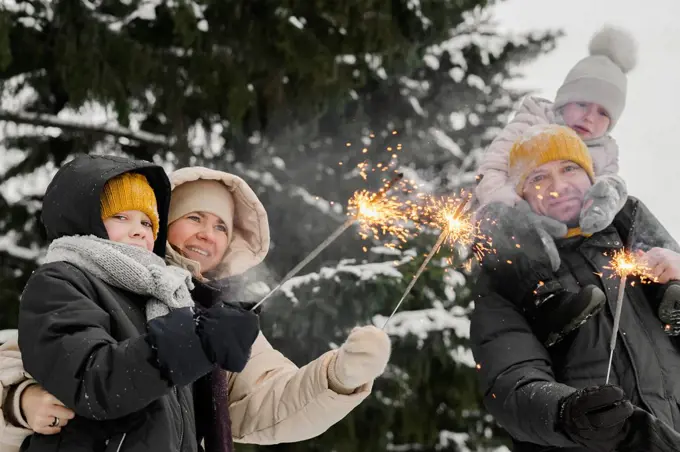 Family with sparklers celebrating in winter