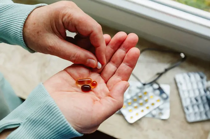 Senior woman with medicine pills in hand