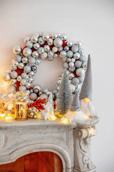 Christmas decoration with illuminated lights on marble fireplace