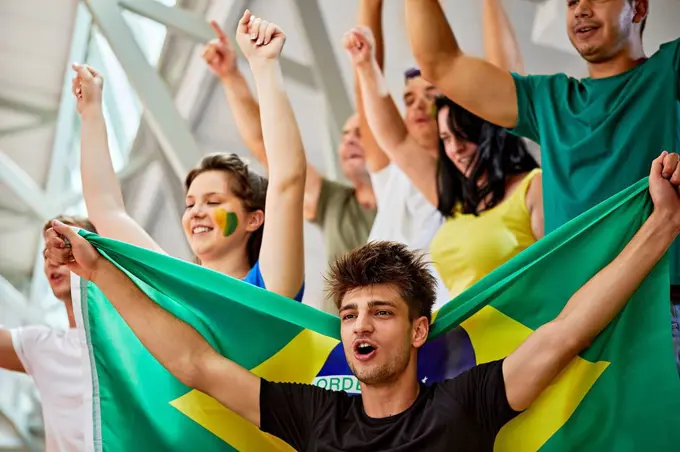 Fans with Brazil Flag shouting together at sports event in stadium