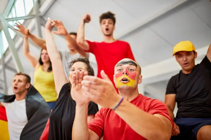 Young fans cheering at sports event in stadium