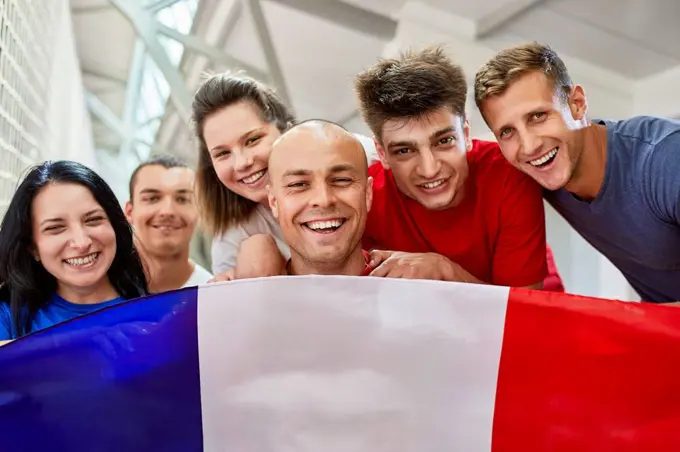 Happy sports fans with French Flag in stadium