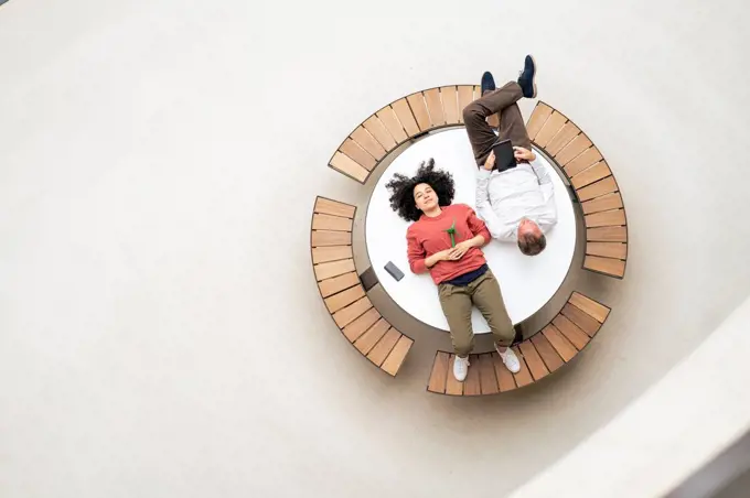 Business colleagues resting on table in office lobby