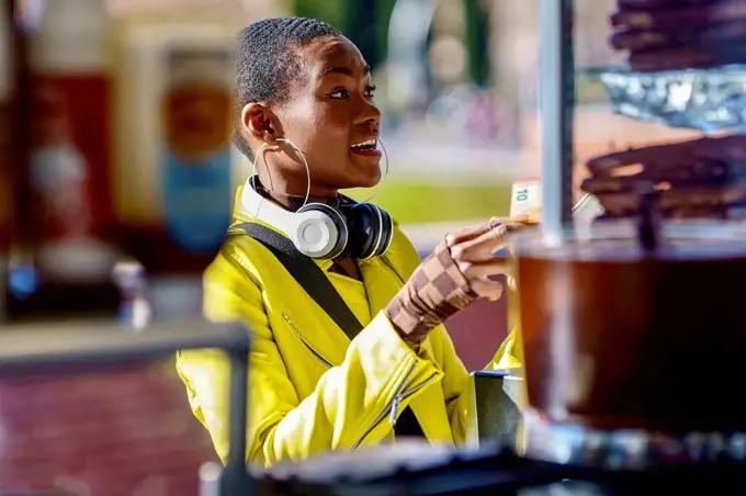 Woman with headphones buying food at concession stand