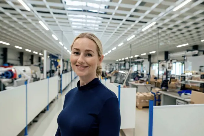 Smiling businesswoman with blond hair in factory